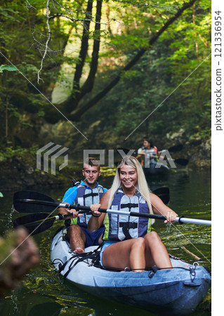 A group of friends enjoying having fun and kayaking while exploring the calm river, surrounding forest and large natural river canyons 121336954