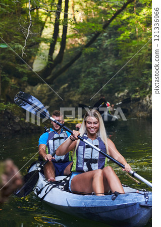 A group of friends enjoying having fun and kayaking while exploring the calm river, surrounding forest and large natural river canyons 121336966