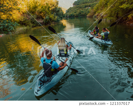 A group of friends enjoying having fun and kayaking while exploring the calm river, surrounding forest and large natural river canyons 121337017