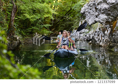 A group of friends enjoying having fun and kayaking while exploring the calm river, surrounding forest and large natural river canyons 121337099