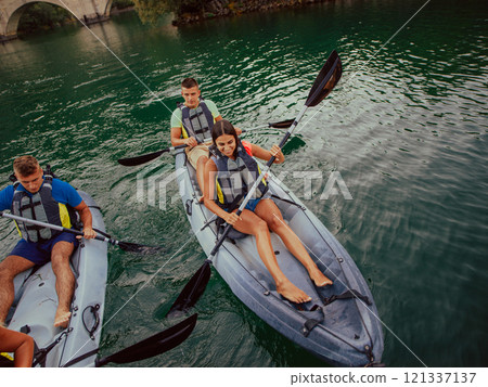 A group of friends enjoying having fun and kayaking while exploring the calm river, surrounding forest and large natural river canyons 121337137
