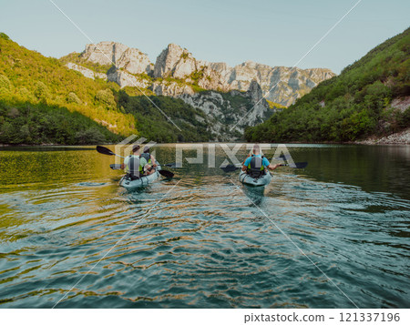 A group of friends enjoying having fun and kayaking while exploring the calm river, surrounding forest and large natural river canyons 121337196