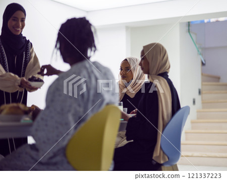 A woman in a hijab extends a platter of dates to her diverse family, creating a scene of unity and joy as they come together to break their fast during the holy month of Ramadan, symbolizing the A woman in a hijab extends a platter of dates to her diverse family, creating a scene of unity and joy as they come together to break their fast during the holy month of Ramadan, symbolizing the 121337223