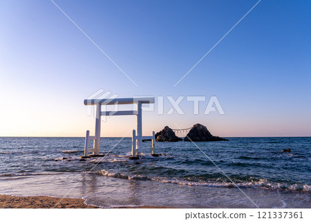Itoshima City, Fukuoka Prefecture: Couple rocks and white torii gates at Sakurai Futamigaura in the evening Itoshima City, Fukuoka Prefecture: Couple rocks and white torii gates at Sakurai Futamigaura in the evening 121337361
