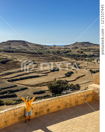 Woman in yellow shirt on a sunny day at Gozo island 121337445