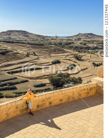 Woman in yellow shirt on a sunny day at Gozo island 121337448