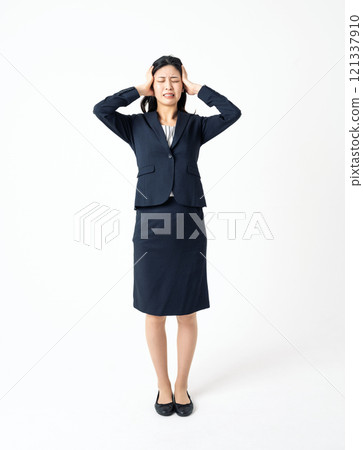 A young woman in a suit holding her head with both hands A young woman in a suit holding her head with both hands 121337910