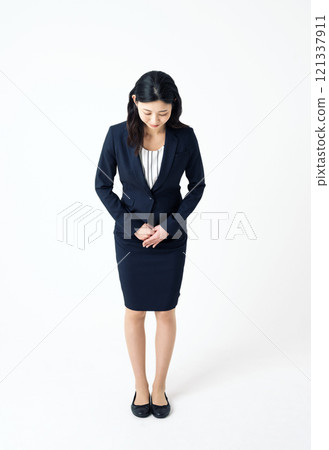 一個穿著西裝的女人鞠躬 一個穿著西裝的女人鞠躬 121337911