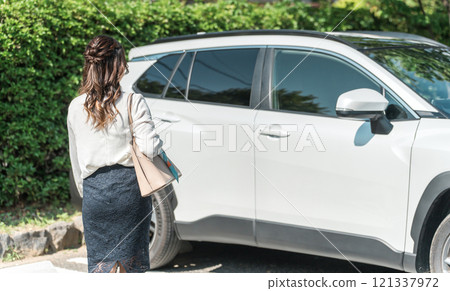 女商人打開/關閉車門並進入駕駛座 女商人打開/關閉車門並進入駕駛座 121337972