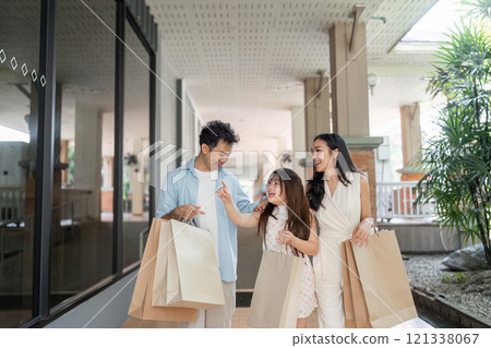 Joyful Family Shopping Experience Parents and Child Enjoying a Day Out with Shopping Bags in a Modern Mall Setting Joyful Family Shopping Experience Parents and Child Enjoying a Day Out with Shopping Bags in a Modern Mall Setting 121338067