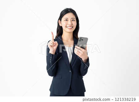 一位身穿西裝的年輕女子拿著智慧型手機，用食指打出一個點標誌 121338219