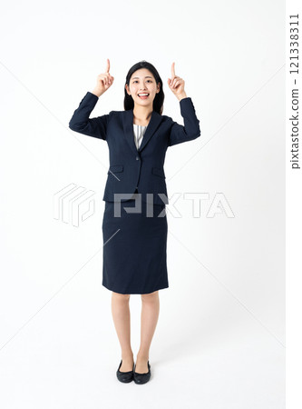 一位穿著西裝的年輕女子的全身肖像，直接指向上方 121338311