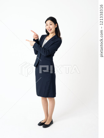 一位身穿西裝的年輕女子指向側面的全身肖像 121338316