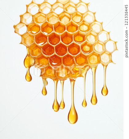 Golden honeycomb dripping with fresh honey against white background, showcasing natural beauty and texture of honeycomb structure 121338445