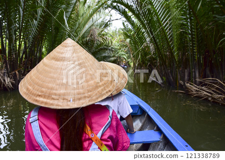 A woman wearing a straw hat is sitting in a boat with a man A woman wearing a straw hat is sitting in a boat with a man 121338789