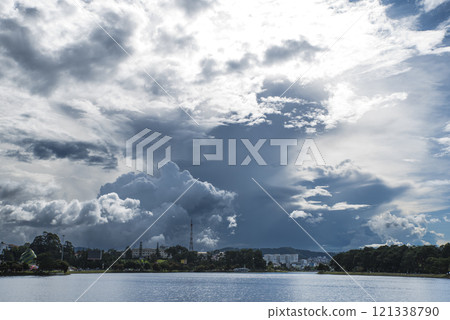 A large cloud is in the sky above a body of water A large cloud is in the sky above a body of water 121338790
