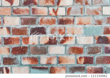 A brick wall with a green and red stripe 121338962