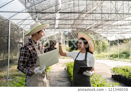 Couple Cultivating an Herbal Garden with Modern Technology in a Greenhouse Setting Couple Cultivating an Herbal Garden with Modern Technology in a Greenhouse Setting 121340038