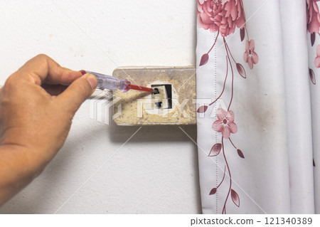 Electrician is fixing old sockets of a residential. Electrician is fixing old sockets of a residential. 121340389