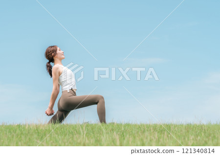 年輕的亞洲女性在藍天下做瑜珈、皮拉提斯和伸展運動 年輕的亞洲女性在藍天下做瑜珈、皮拉提斯和伸展運動 121340814