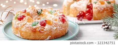 Three kings holiday festive fruitcake topped with colorful candied fruits on a table, background 121342751
