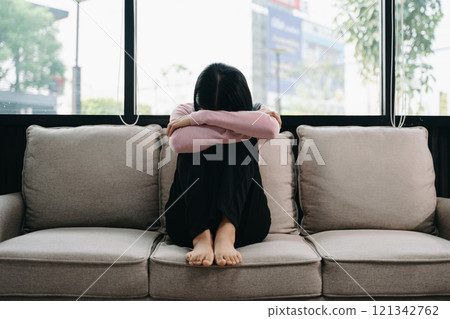 woman sit Depression Standing by window and anxiety Copy space. 121342762