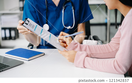 Female doctor using clipboard is delivering great news talk discuss results or symptoms with female patient in clinic or hospital 121342837