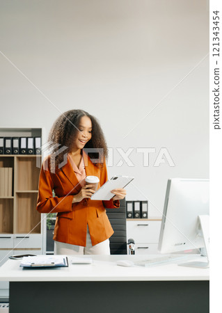 Confident business expert attractive smiling young woman holding digital tablet  on desk in creative office. 121343454