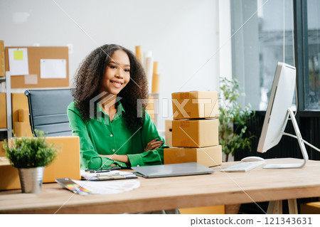 Young business owner woman prepare parcel box and standing check online orders for deliver Young business owner woman prepare parcel box and standing check online orders for deliver 121343631