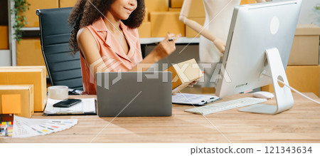 Young business owner woman prepare parcel box and standing check online orders for deliver Young business owner woman prepare parcel box and standing check online orders for deliver 121343634