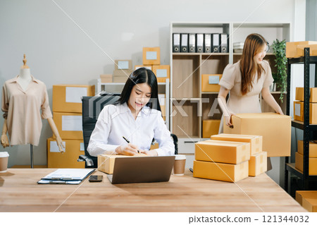 Small business entrepreneur SME freelance Asian woman and woman working at home office 121344032