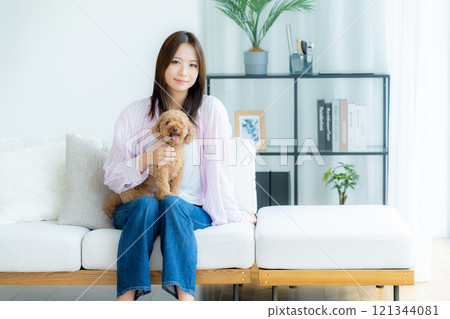 Young woman relaxing with her pet in her room Young woman relaxing with her pet in her room 121344081