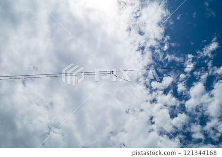 A thin cable floating in the blue sky 121344168