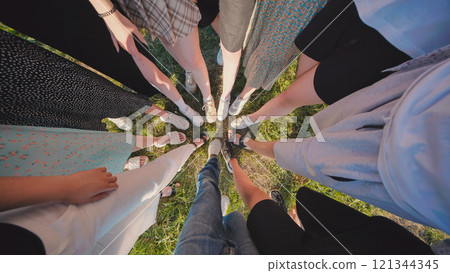 High school students gather in a circle outdoors during the summer, representing unity, friendship, and teamwork 121344345