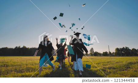 Graduates joyfully throwing books into the air, celebrating the exciting end of high school and embracing new beginnings together 121344458