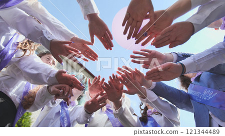 Students forming a circle, uniting in celebration of their graduation and last day of school in 2024, representing solidarity and camaraderie 121344489