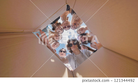 School friends open the box and are surprised. The view from the box. Then they close the box. 121344492