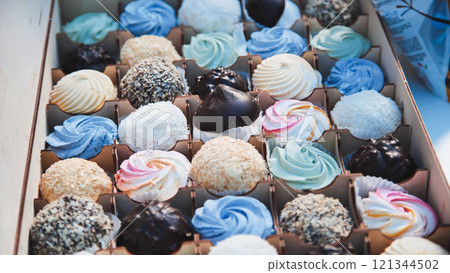 Tempting display of sweetness, marshmallows and chocolate cakes arranged in a wooden box Tempting display of sweetness, marshmallows and chocolate cakes arranged in a wooden box 121344502