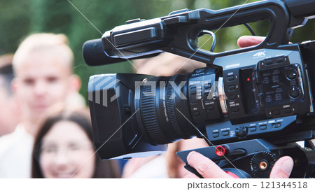 Videographer using a professional camcorder is recording group of students on their first school day 121344518