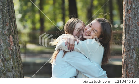 Two happy students hugging in a beautiful park, commemorating their friendship and academic success amid the beauty of nature Two happy students hugging in a beautiful park, commemorating their friendship and academic success amid the beauty of nature 121344519