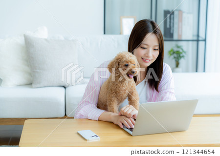 Young woman relaxing with her pet in her room 121344654