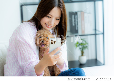 Young woman relaxing with her pet in her room 121344883