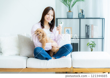 Young woman relaxing with her pet in her room 121344885
