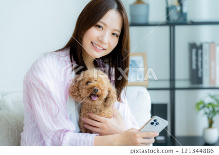 Young woman relaxing with her pet in her room Young woman relaxing with her pet in her room 121344886