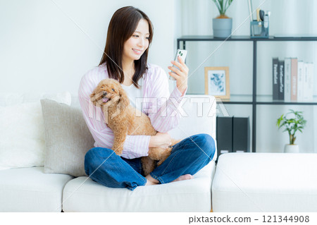 年輕女子和她的寵物在房間裡放鬆 121344908