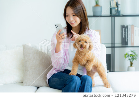 Young woman relaxing with her pet in her room 121345279