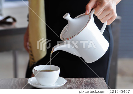 pouring tea , tea cup and tea pot or hot tea 121345467