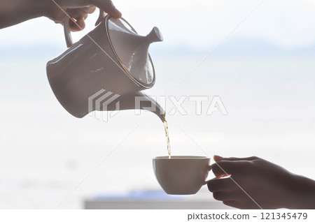 pouring tea , tea cup or hot tea pouring tea , tea cup or hot tea 121345479