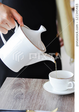 pouring tea , tea cup and tea pot or hot tea 121345483