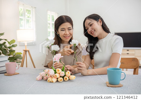 Mother and Daughter Bonding Over Flower Arrangement in a Bright and Cozy Home Setting Mother and Daughter Bonding Over Flower Arrangement in a Bright and Cozy Home Setting 121346412